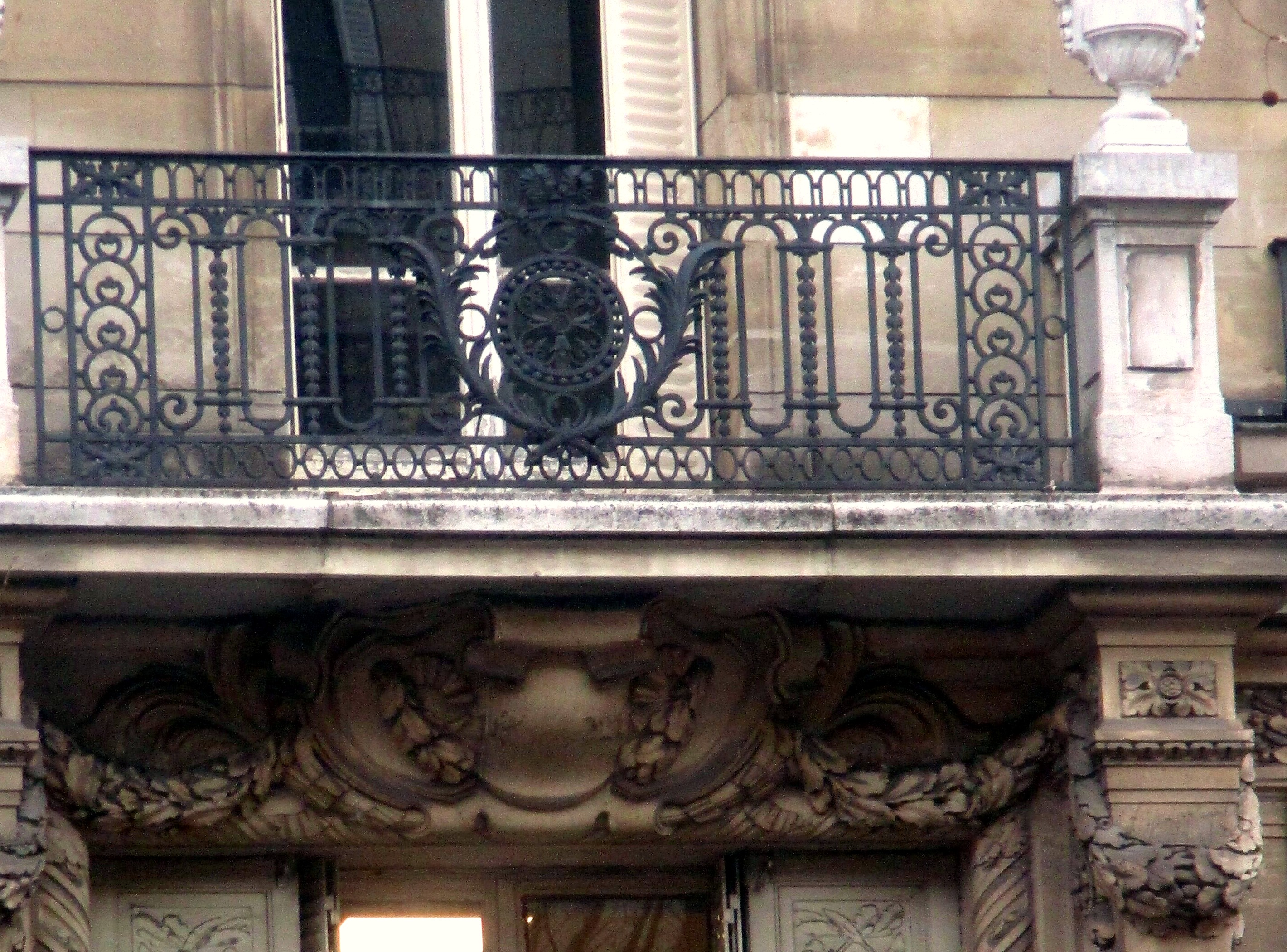 Balcon en fer forgé et pierre sculptée d’un immeuble haussmannien parisien